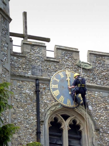 workmen abseiling down the clock tower