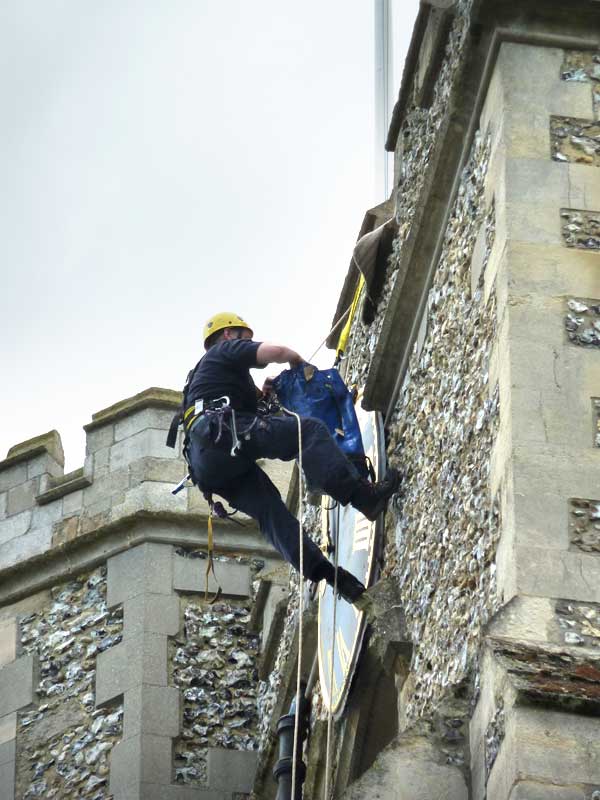 workmen abseiling down the clock tower